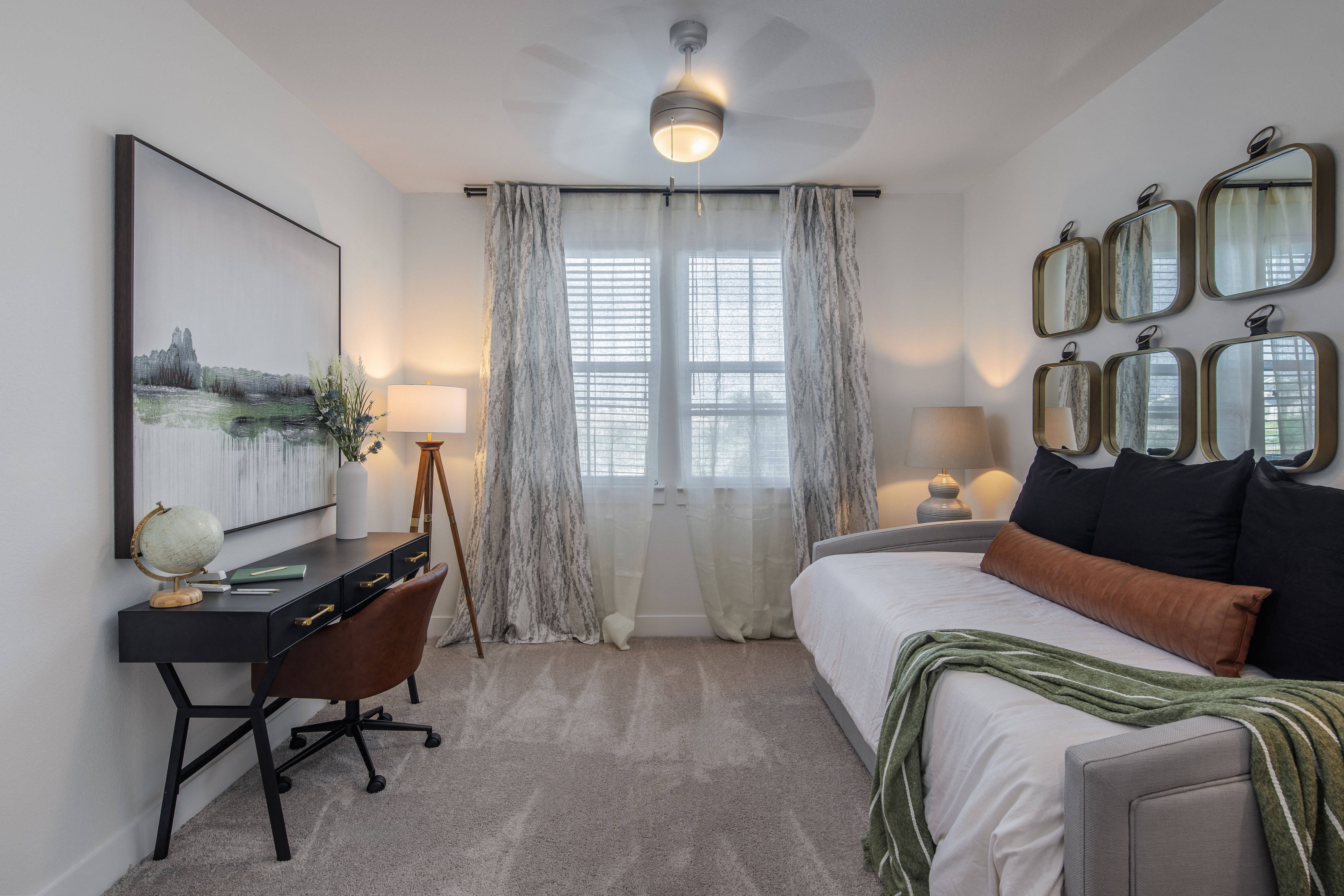a bedroom with a daybed and desk at a senior apartment community